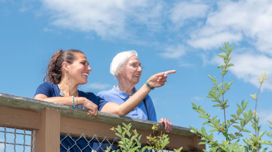 ASQ Caregiver point at a location in distant forward, while elderly client looks along.